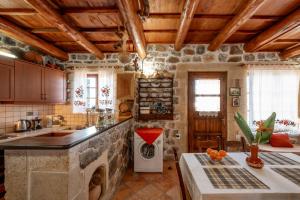una cucina con pareti in pietra e soffitti in legno di Maria's Serene Countryside Retreat by Chania a Maláxa