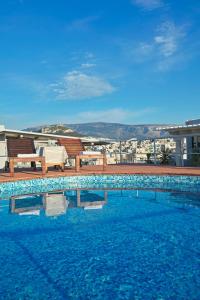 una piscina con bancos y vistas a la ciudad en Candia Hotel, en Atenas