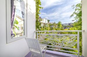Biały fotel na balkonie z widokiem w obiekcie Hese Dalat Boutique Resort w mieście Da Lat