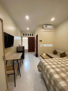 Schlafzimmer mit einem Bett, einem Tisch und einem Schreibtisch in der Unterkunft Light House Residence Denpasar Bali in Denpasar