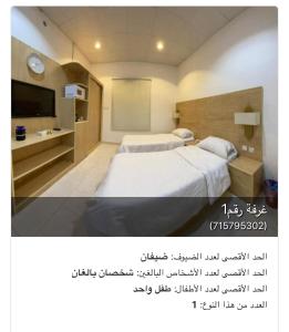 Pokój z dwoma łóżkami i telewizorem w obiekcie شقق شاطئ النخيل w mieście Umm Lajj