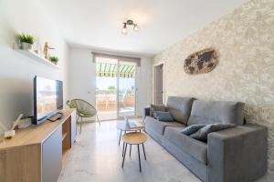 a living room with a couch and a tv at TrendyHomes Puerto - Vistas al mar, parking incluido, playa a un paso in Aguadulce