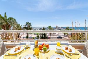 a table with food on a balcony with a view of the ocean at TrendyHomes Puerto - Vistas al mar, parking incluido, playa a un paso in Aguadulce