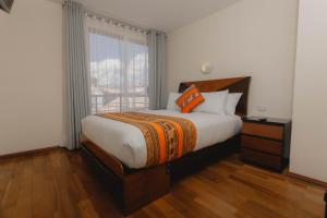 sypialnia z dużym łóżkiem i oknem w obiekcie Quechua ApartHotel w Cuzco