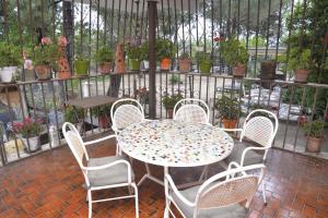 un patio con mesa, sillas y plantas en La Pedriza en Galapagar