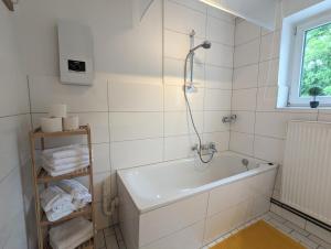 a white bathroom with a tub and a shower at Monteur Atelier in Marl +18 photos