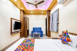 a bedroom with a bed and a blue chair at FabHotel Kanan Inn in kolkata