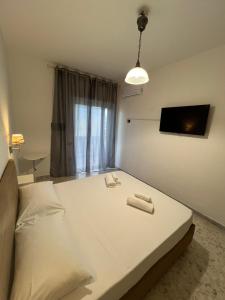 a bedroom with a large white bed and a tv at Sweet Home Capodimonte in Naples
