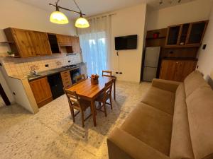 a kitchen and living room with a couch and a table at Sweet Home Capodimonte in Naples