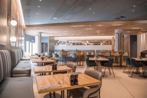 a restaurant with wooden tables and chairs and tablesktop at Courtyard by Marriott Paris Arcueil in Arcueil