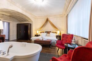 ein Hotelzimmer mit einer Badewanne und einem Bett in der Unterkunft Batschari Palais Baden-Baden in Baden-Baden