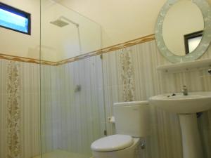 een badkamer met een toilet, een wastafel en een spiegel bij Puri Asri Bungalow Ubud in Ubud