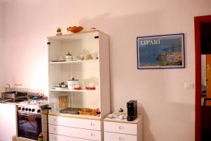 a kitchen with a white cabinet with food on it at La Torre guest house in Acireale