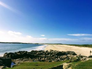 a beach with a bunch of rocks and the ocean at Errisbeg Lodge Bed + Breakfast in Roundstone +13 photos