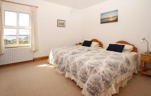 a bedroom with two beds and a window at Errisbeg Lodge Bed + Breakfast in Roundstone