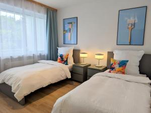 a bedroom with two beds and two lamps and a window at Monteur Atelier in Marl
