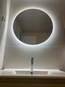 ein Waschbecken mit einem runden Spiegel darüber in der Unterkunft Villa La Palmeraie Puerto de la Duquesa in Manilva + 29 Fotos