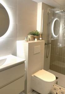 ein Badezimmer mit Toilette, Waschbecken und Dusche in der Unterkunft Villa La Palmeraie Puerto de la Duquesa in Manilva