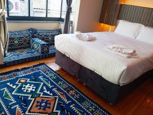 een slaapkamer met een bed, een bank en een tapijt bij Bonita Boutique in Istanbul +17 foto's