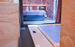 riflessione di una camera da letto con un letto in uno specchio di Masseria Elysium a Mesagne