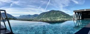 una piscina de agua con vistas a la montaña en SomVita Suites, en Tirolo