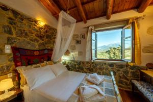 ein Schlafzimmer mit einem Bett in einer Steinmauer in der Unterkunft Maria's Serene Countryside Retreat by Chania in Maláxa