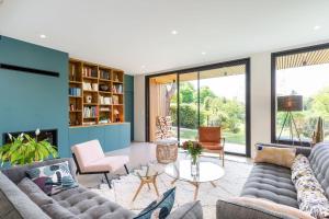 a living room with couches and a fireplace at Souvenirs architect's house with pool and garden in Écully