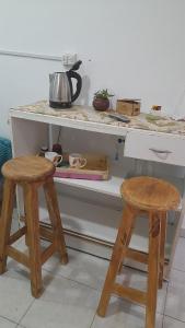 a kitchen with two wooden stools and a counter at Hospedaje Luna in Chajarí +4 photos
