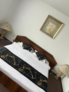 Un pat sau paturi într-o cameră la Pensiunea Dacia Deva