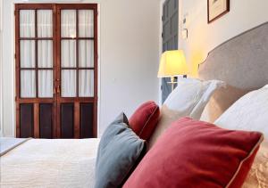 a bedroom with a bed with pillows and a window at Castillo de Corvinos in Huesca