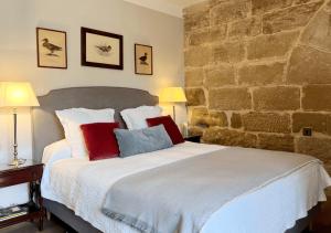 ein Schlafzimmer mit einem großen Bett mit roten und blauen Kissen in der Unterkunft Castillo de Corvinos in Huesca
