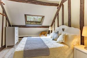a bedroom with a bed and a window at Epicéas, piscine, tennis, lac in Guerquesalles