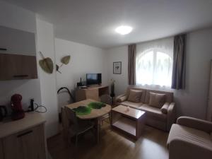 uma sala de estar com um sofá e uma mesa em Apartament Messambria Resort - Bastet BS em Sunny Beach