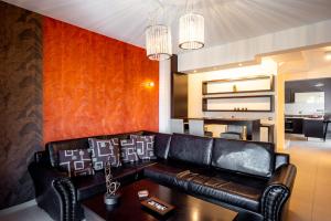 a living room with a leather couch and a table at Villa Miami in Agia Marina Nea Kydonias