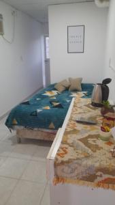 a bed with a blue comforter in a room at Hospedaje Luna in Chajarí