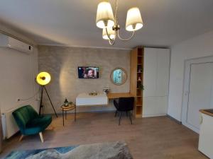 uma sala de estar com uma secretária e uma cadeira verde em Apartments Marina em Apatin