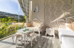 大叻的住宿－Hese Dalat Boutique Resort，白色的客房配有桌椅和窗户。