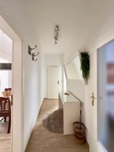 biały korytarz ze schodami w domu w obiekcie Seestern w mieście Warnemünde