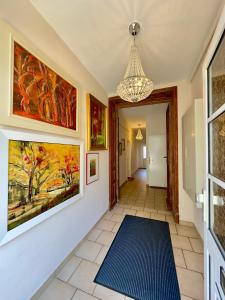 a hallway with paintings on the walls and a chandelier at Seestern in Warnemünde