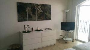 a bedroom with a dresser with a tv and a bed at Playas Gemelas Puerto Vallarta in Puerto Vallarta