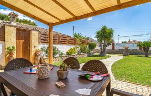 eine Terrasse mit Tisch und Stühlen unter einer Pergola in der Unterkunft Nice Home In Chiclana De La Fronter in Chiclana de la Frontera + 13 Fotos