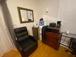 a living room with a chair and a mirror at Harmony place to stay close to all fun in Jersey at 15 minutes to NY City in North Bergen