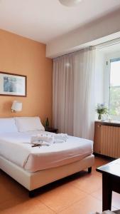 Un dormitorio con una gran cama blanca y una ventana en Villa Eur Parco Dei Pini en Roma