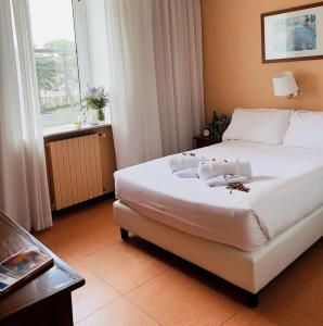 una camera da letto con un grande letto bianco e una finestra di Villa Eur Parco Dei Pini a Roma