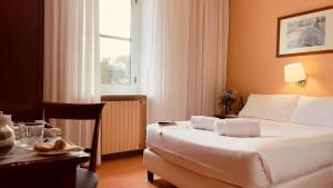 una camera d'albergo con letto, tavolo e scrivania di Villa Eur Parco Dei Pini a Roma