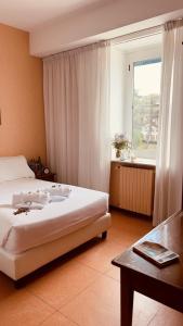 a bedroom with a bed and a table and a window at Villa Eur Parco Dei Pini in Rome