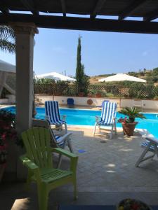 a group of chairs sitting next to a swimming pool at Agriturismo Adenzia in Porto Empedocle