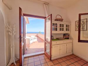 a kitchen with a door open to a balcony at Trilocale Maestrale Beach in Portoferraio