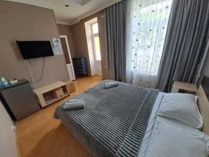 ein Schlafzimmer mit einem Bett und einem großen Fenster in der Unterkunft Guest House Akhaltsikhe in Achalziche
