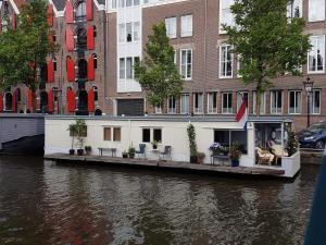 a house on the side of a river at Pantheos Top Houseboat in Amsterdam